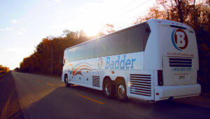 badder_bus_driving_down_a_long_road_as_the_sun_sets